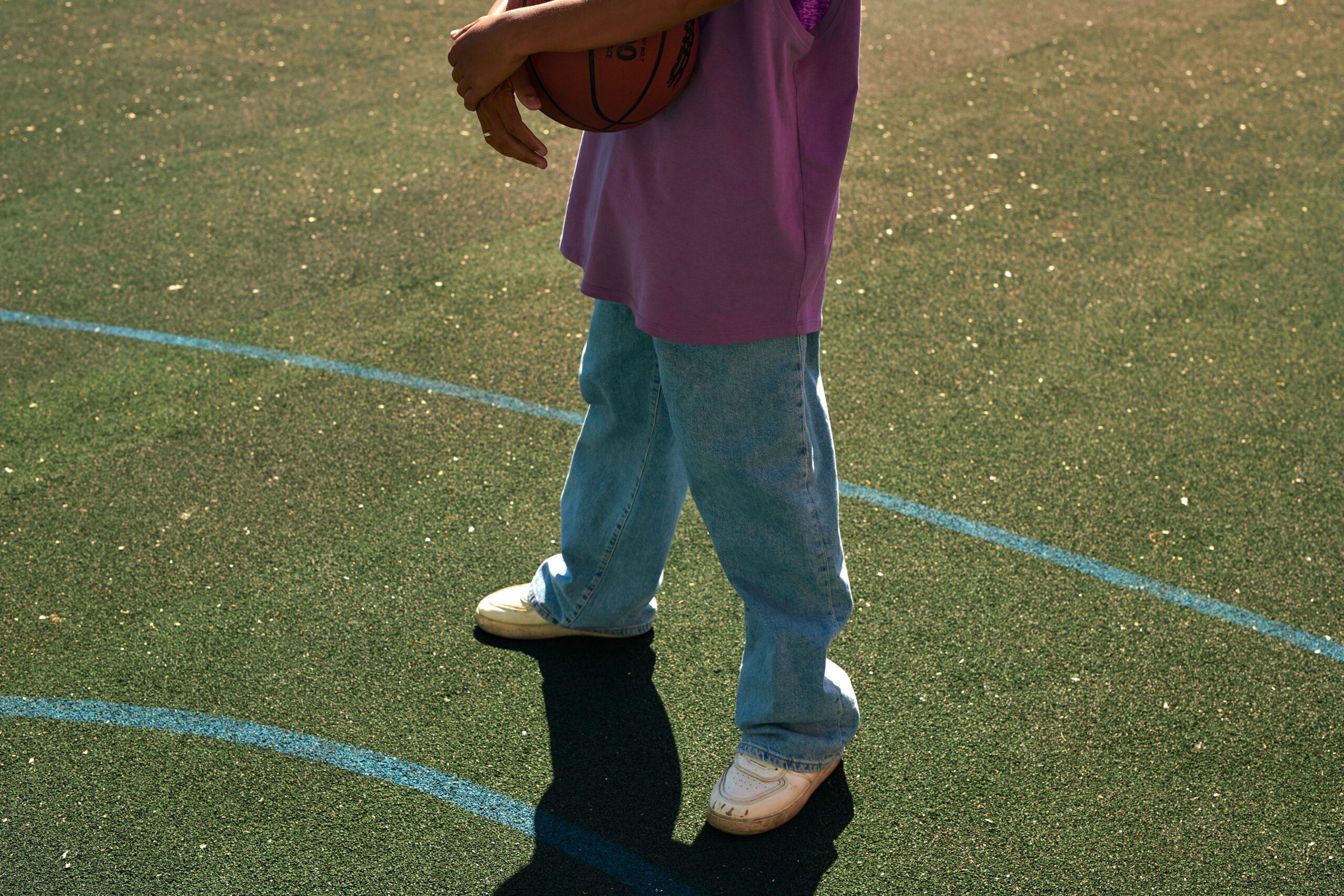 pexels photo 10397637 10397637 Person holding a basketball on an outdoor court in casual attire.