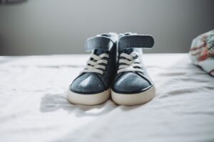 Close-up of trendy denim sneakers on a bed, perfect for fashion enthusiasts.