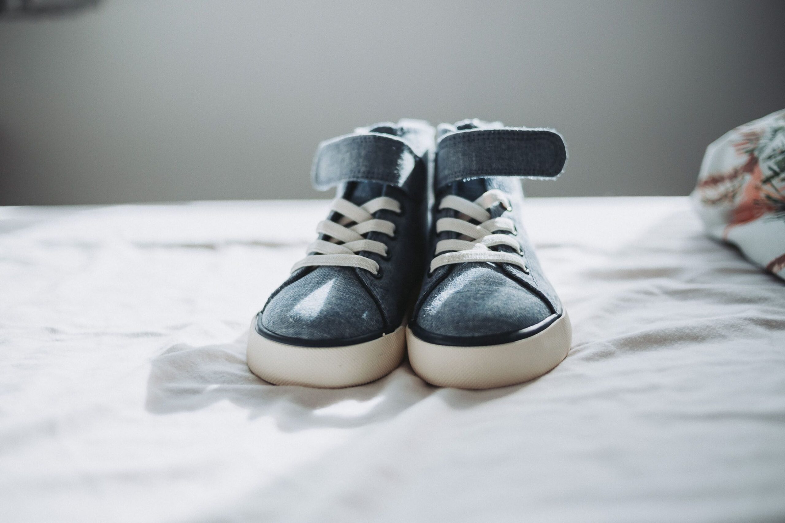 pexels photo 16762445 16762445 Close-up of trendy denim sneakers on a bed, perfect for fashion enthusiasts.