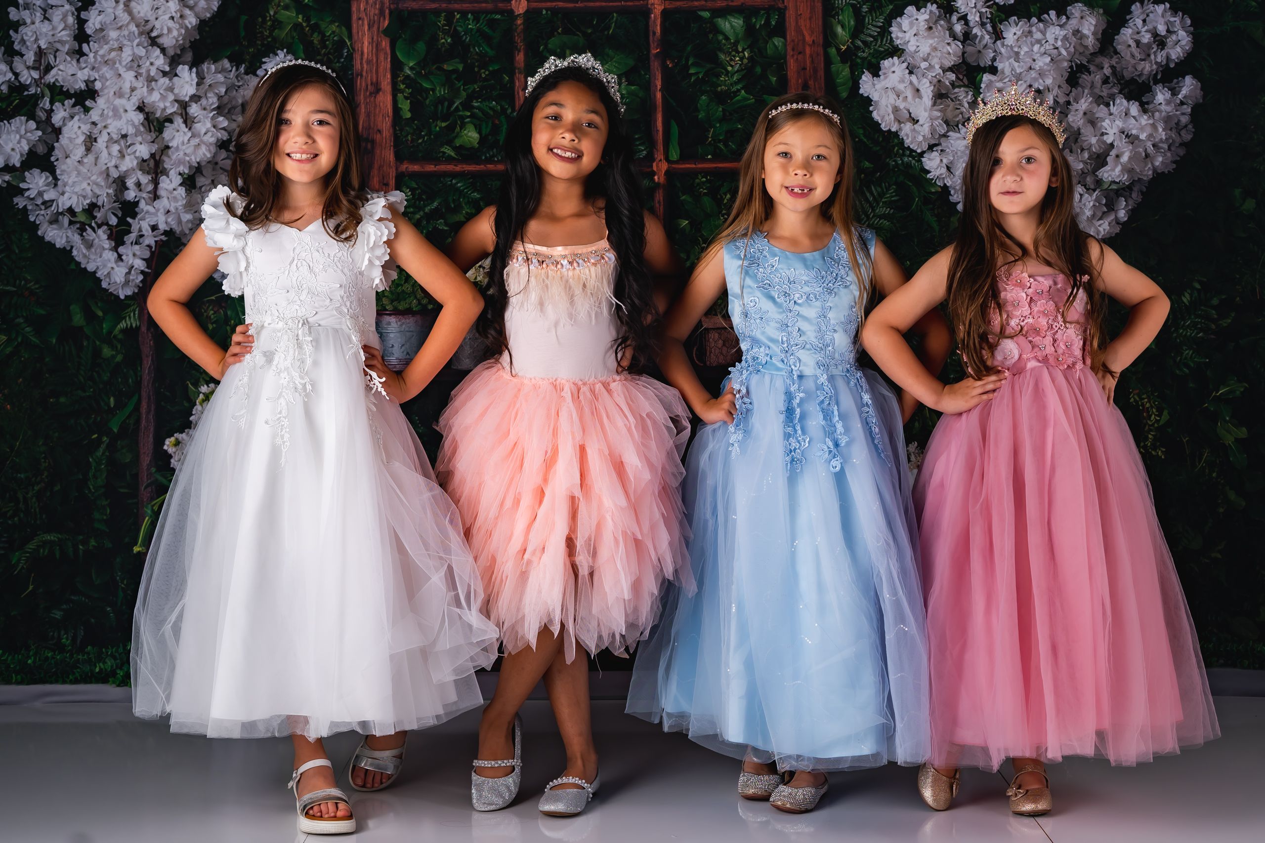 pexels photo 17722721 17722721 A cheerful group of girls in colorful dresses and crowns posing happily indoors.